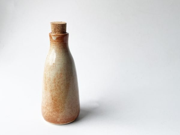 rusted white ceramic bottle